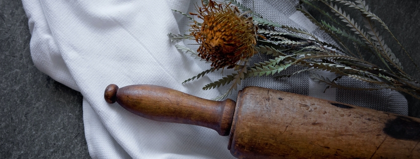 Antique rolling pin, dried flower and tea towel
