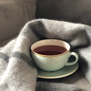 White ceramic cup and saucer with wool blanket