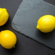 Three Lemons on Black Cutting Board